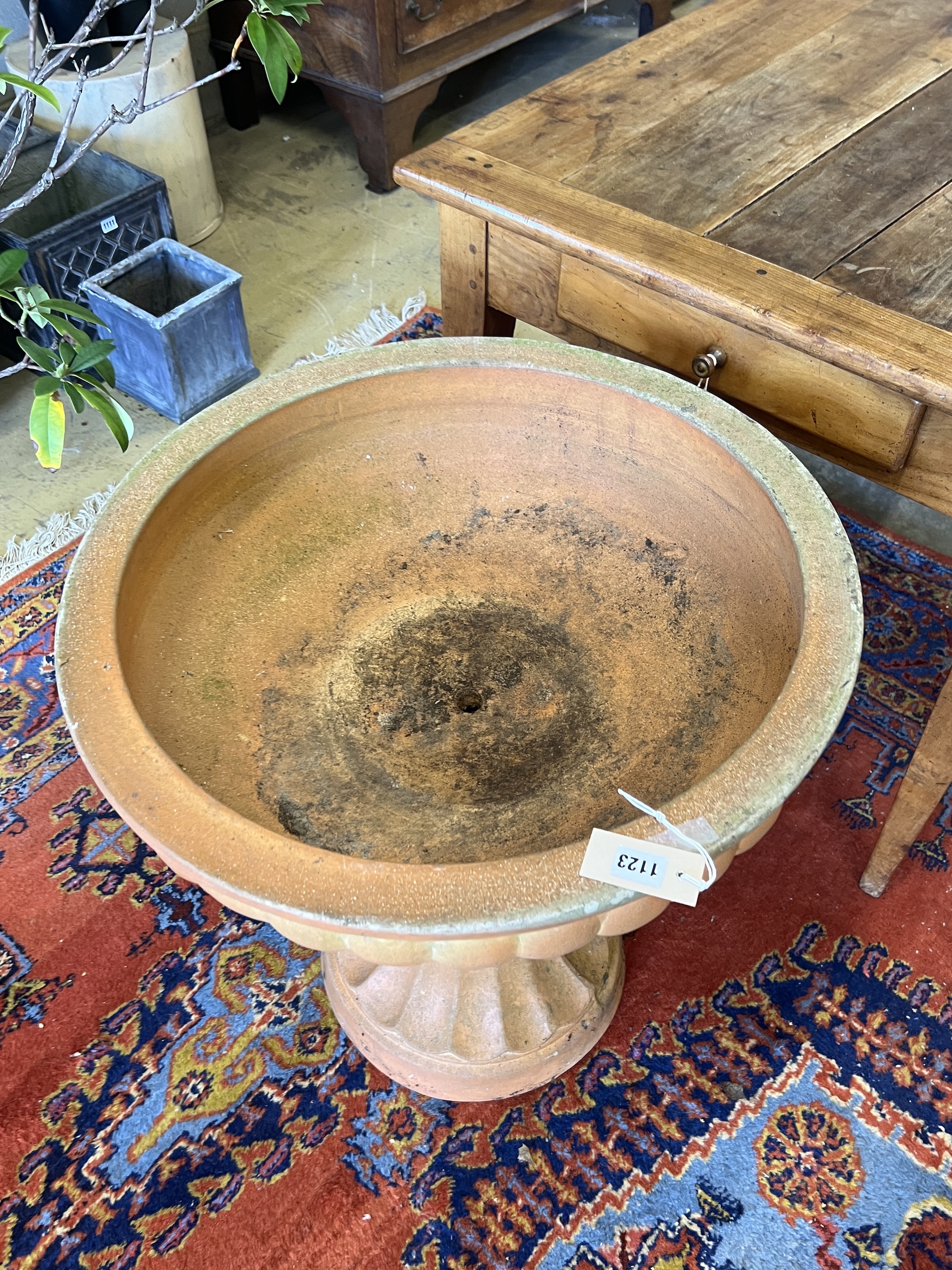 A circular terracotta garden planter, diameter 60cm, height 67cm